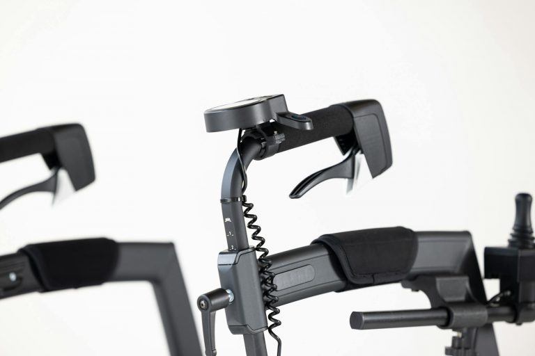 Close-up of modern motorized wheelchair controls against a white studio background.
