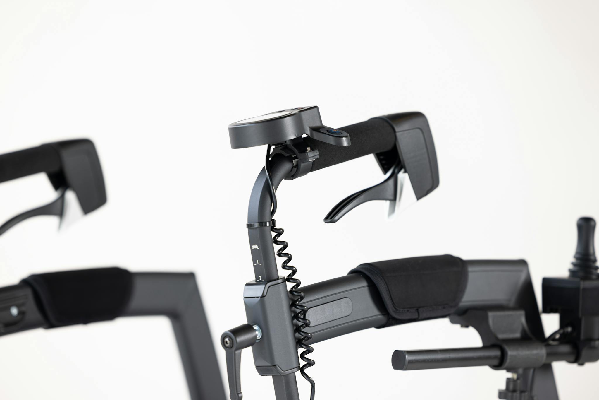 Close-up of modern motorized wheelchair controls against a white studio background.